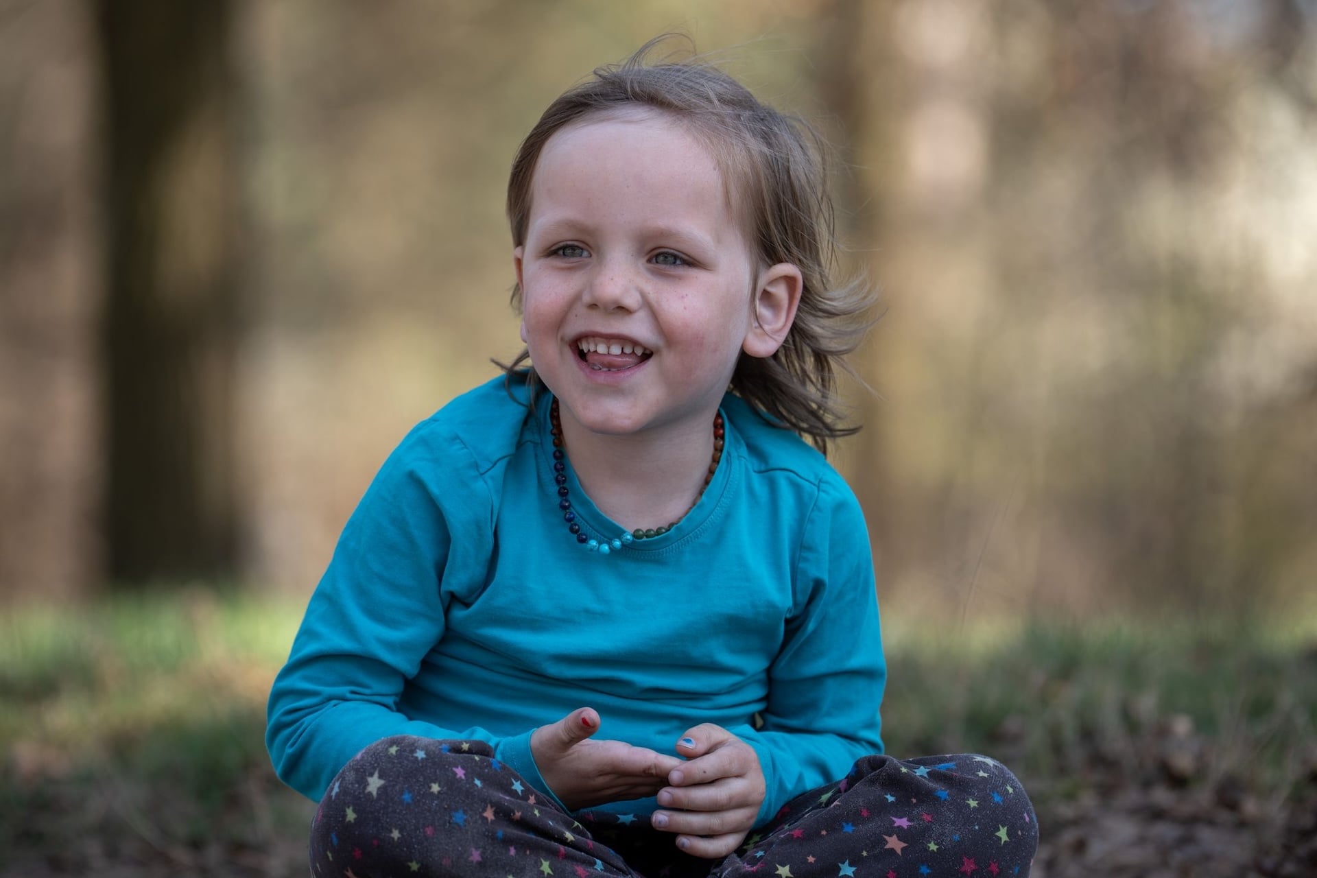 kind alleen op de foto dat lacht met een rustige natuurlijke achtergrond.