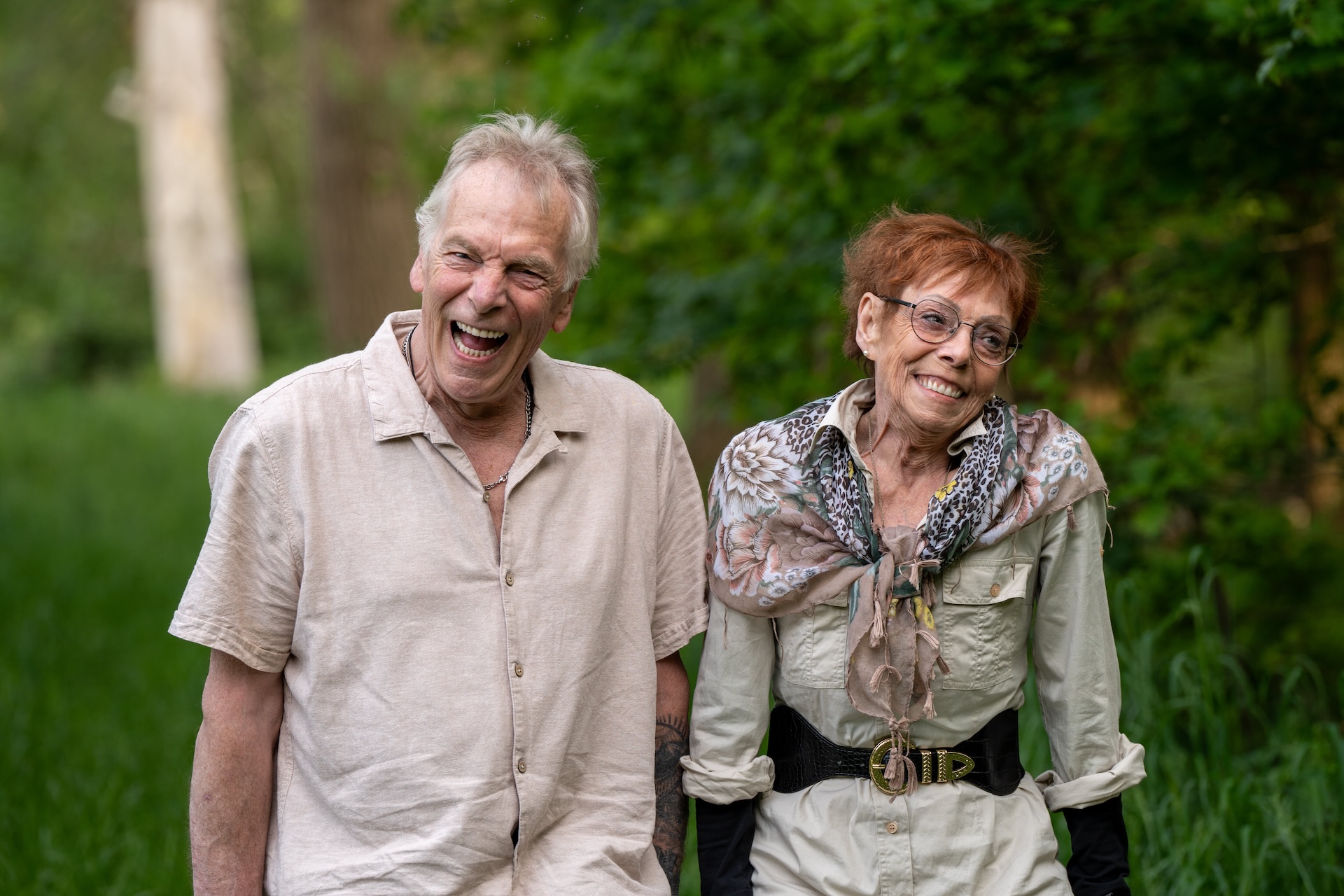 Zus en broer lachen same in het bos, hebben veel plezier samen.