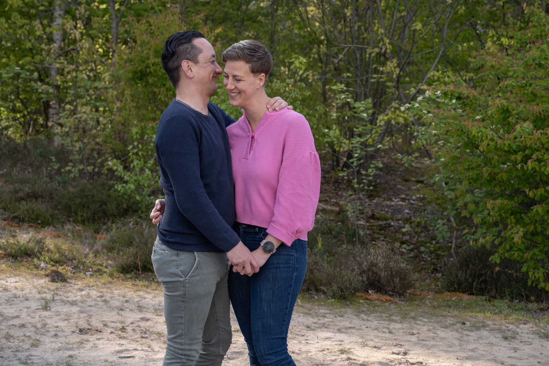 Ongedwongen loveshoot van verliefd stel in het bos met echte connectie voor elkaar.